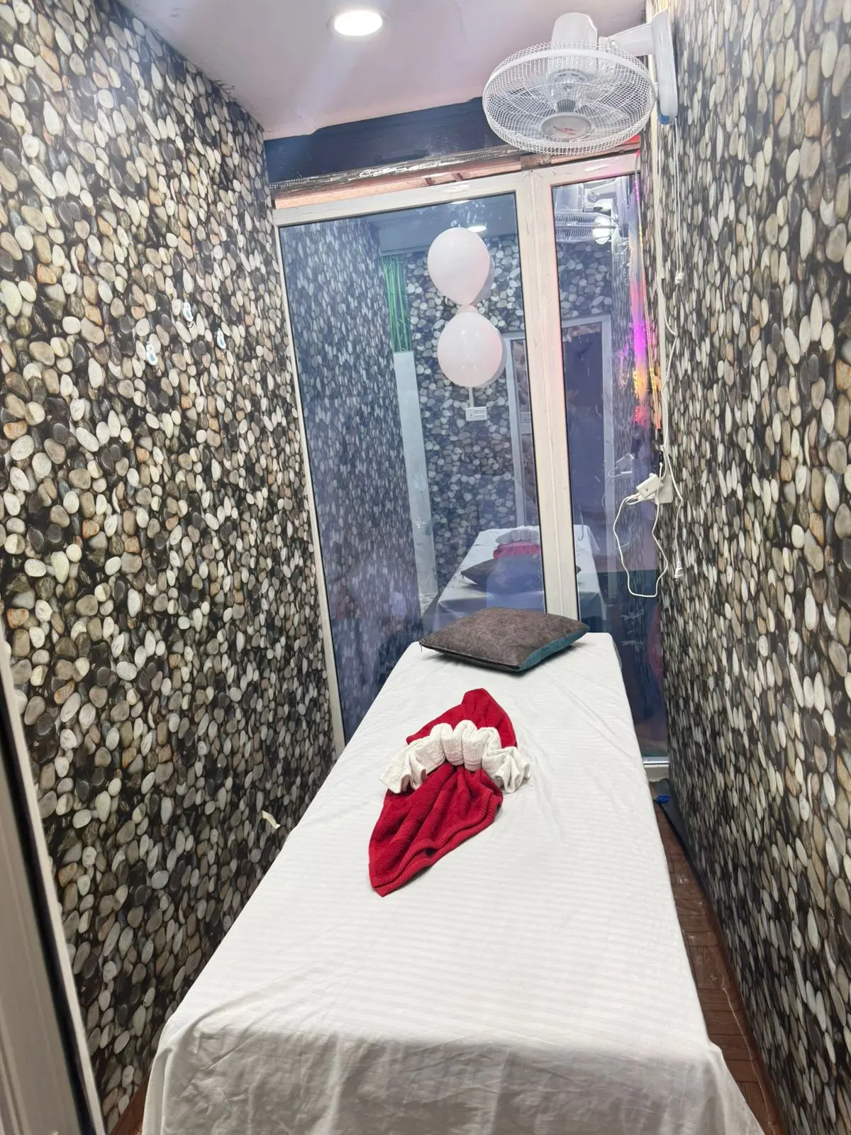 Massage room with pebble-stone walls and a single treatment table
