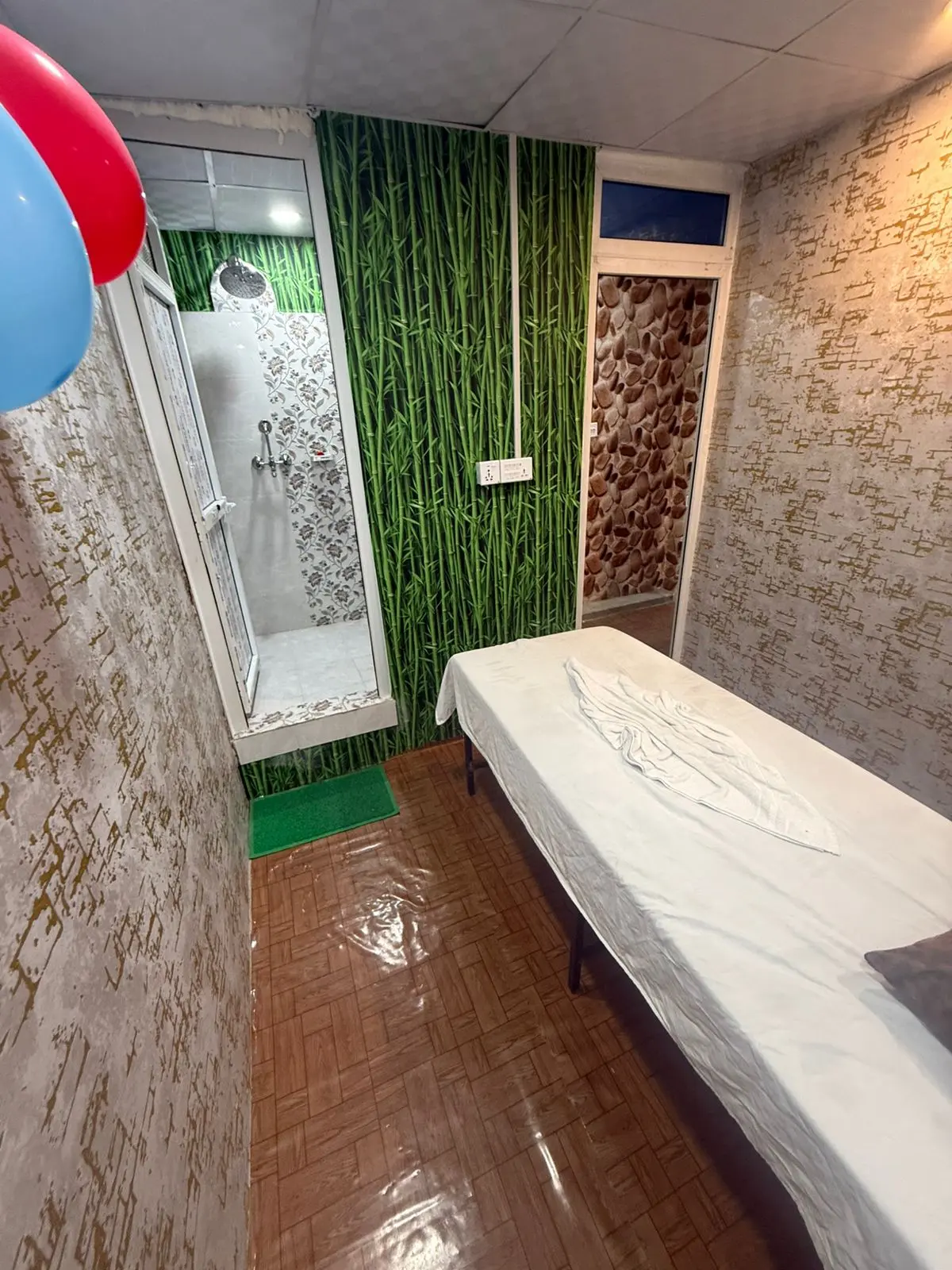 Treatment room with a fresh bamboo green wall accent and shower